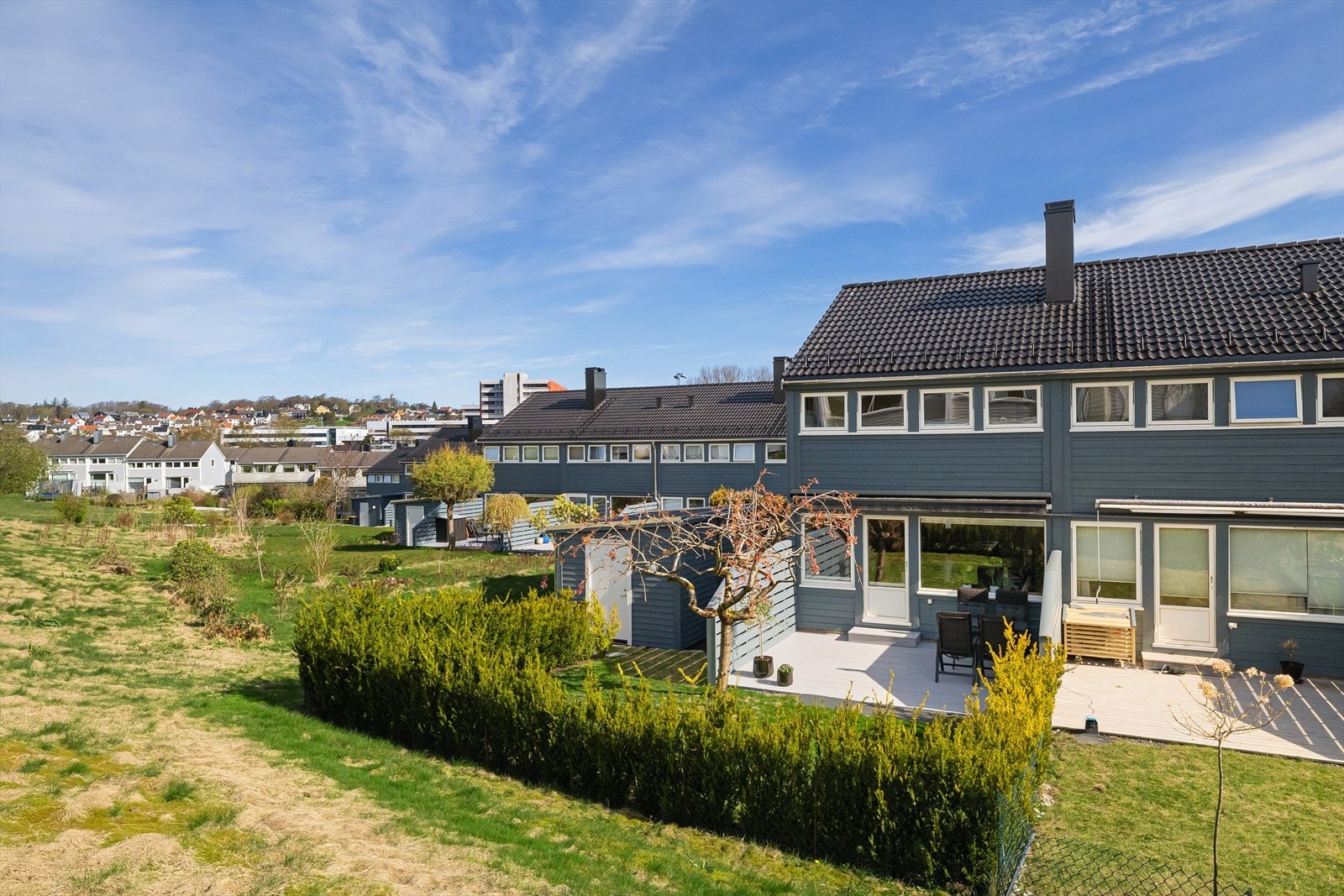 Uteområdet er pent opparbeidet med hekk og plen, og grenser mot felles grøntareal. Galleribilde