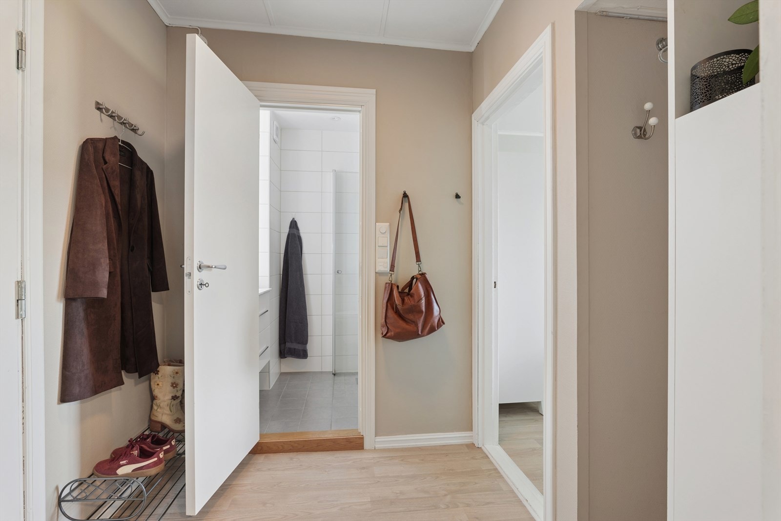 Man kommer inn i entrè med lettstelt laminat på gulv og malte vegger Galleribilde
