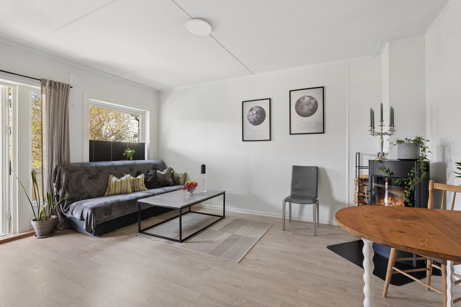 Fra entrè kommer man inn i lys og innbydende stue med laminat på gulv og malte vegger Galleribilde