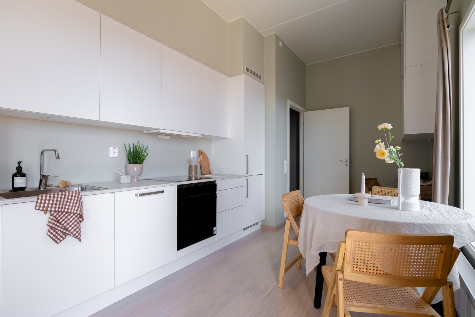 Flott Sigdal-kjøkken i lys, glatt utførelse med laminat benkeplate og nedsenket oppvaskkum med ett-greps blandebatteri. Galleribilde