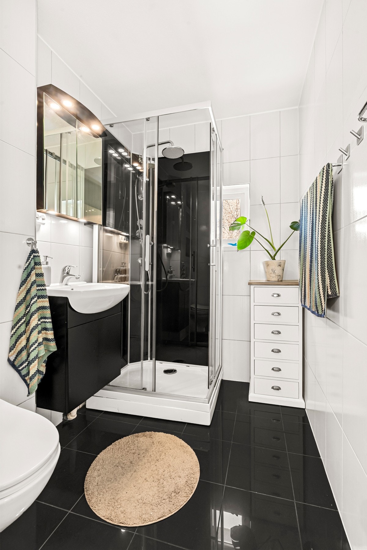 Badet er utstyrt med gulvmontert toalett og dusjhjørne. Galleribilde