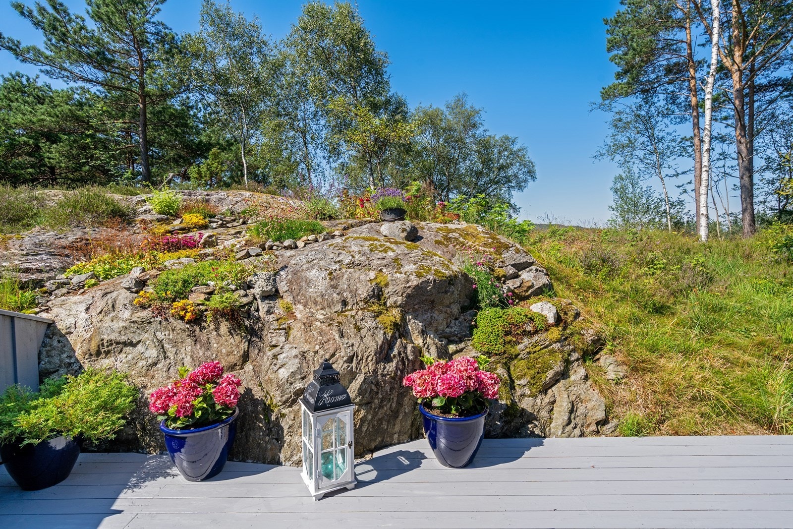 Den store markterrassen er omkranset av et pent opparbeidet uteområde med svaberg og beplantning. Galleribilde