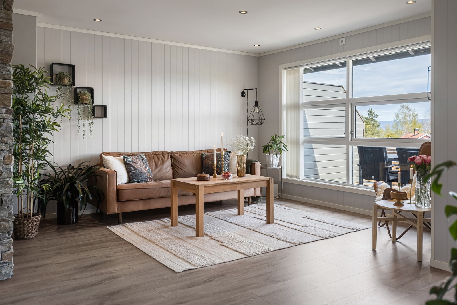 Boligens stue er lys og luftig, med store vindusflater som slipper inn rikelig med dagslys og samtidig gir en flott utsikt mot omgivelsene. Galleribilde