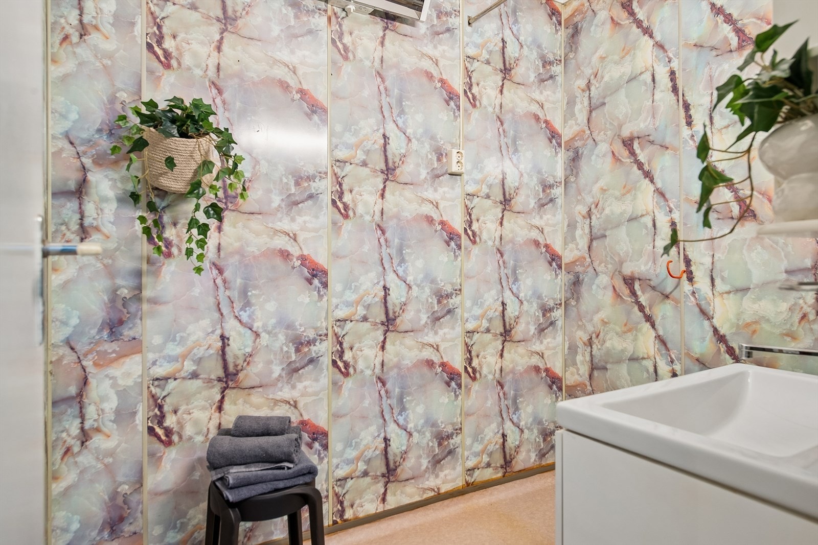 Badet er innredet med baderomsplater på veggene. Galleribilde