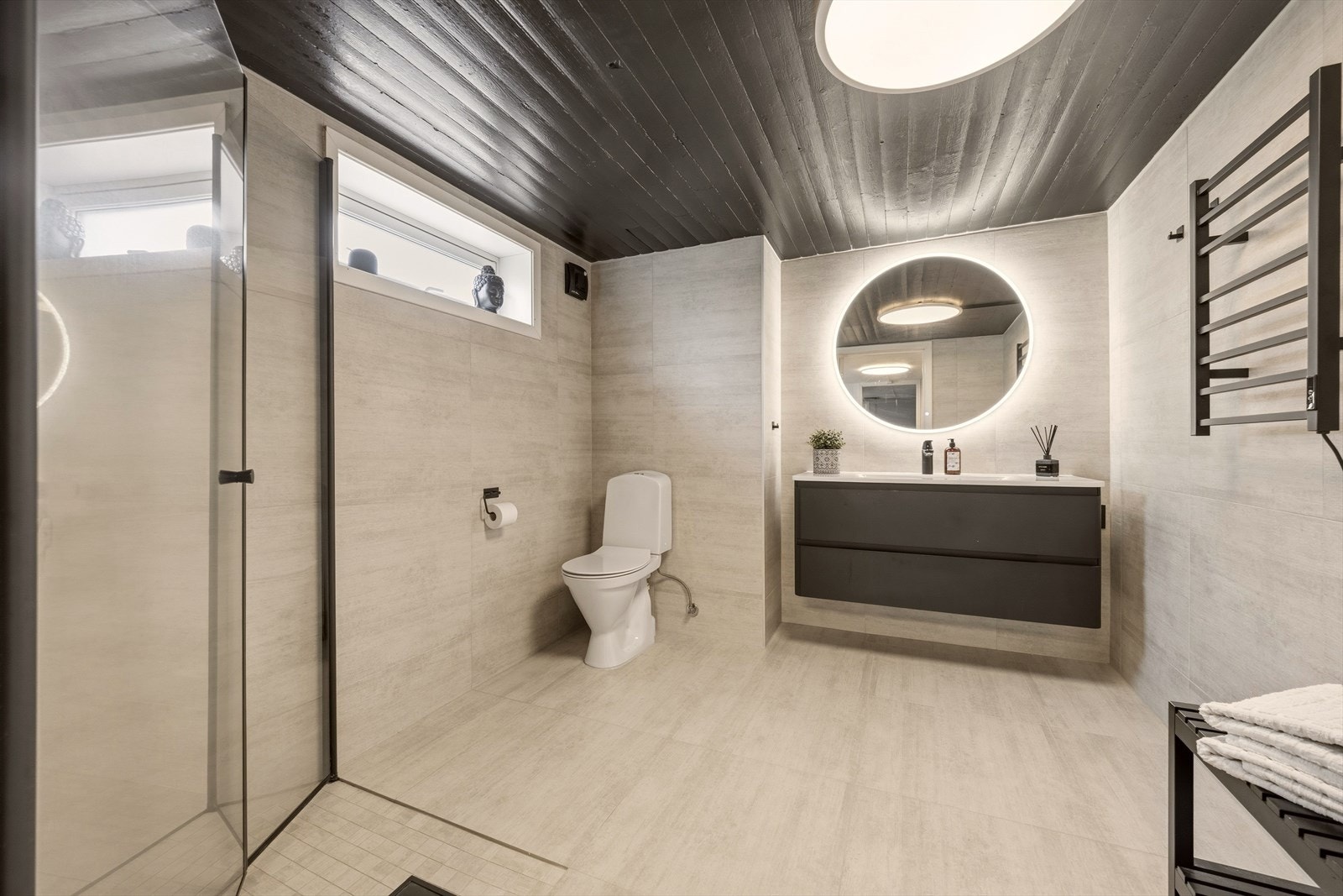 Badet er utstyrt med moderne innredning, toalett og dusjnisje med innfellbare glassdører Galleribilde
