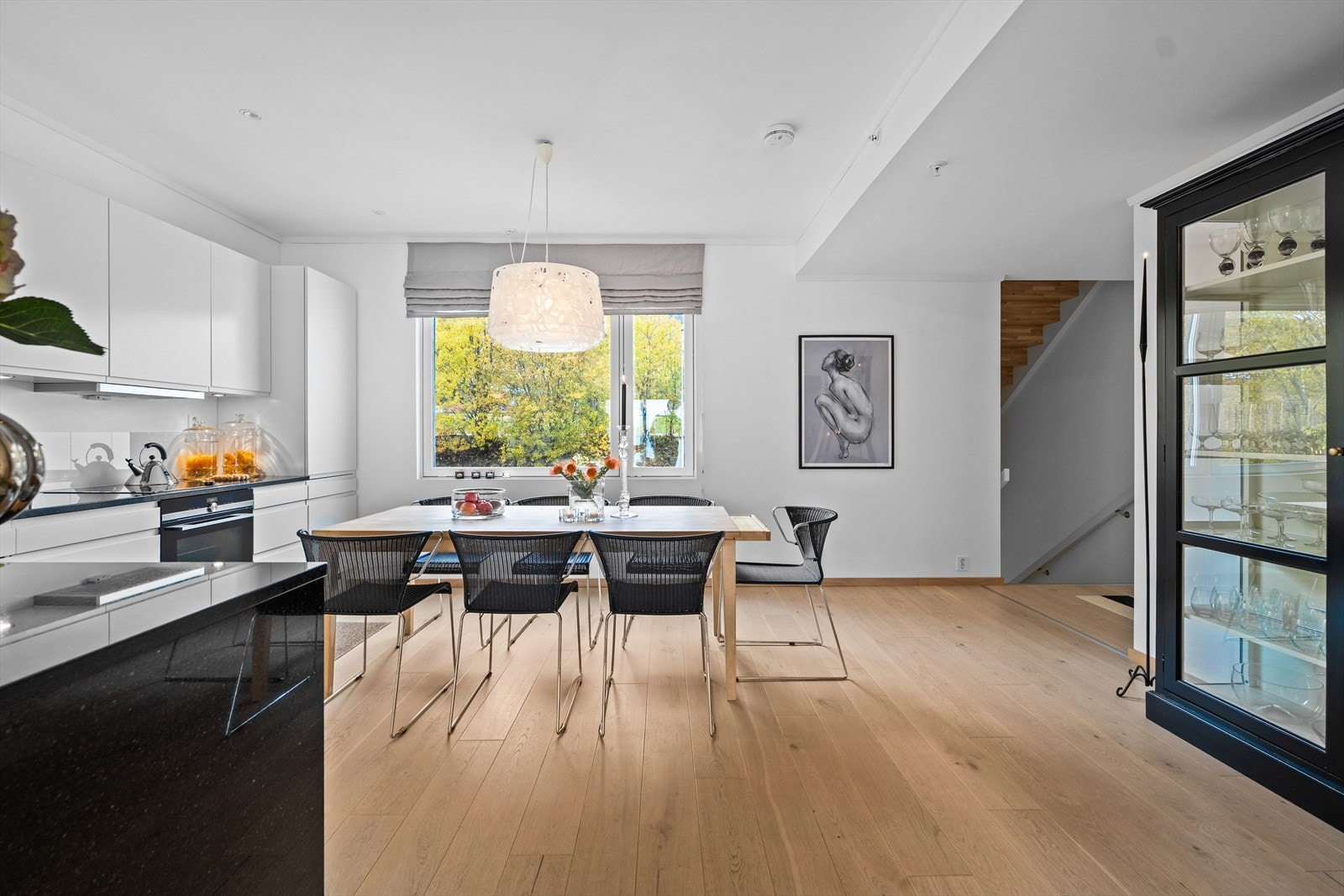 God plass til stor spisegruppe og vitrineskap. Galleribilde