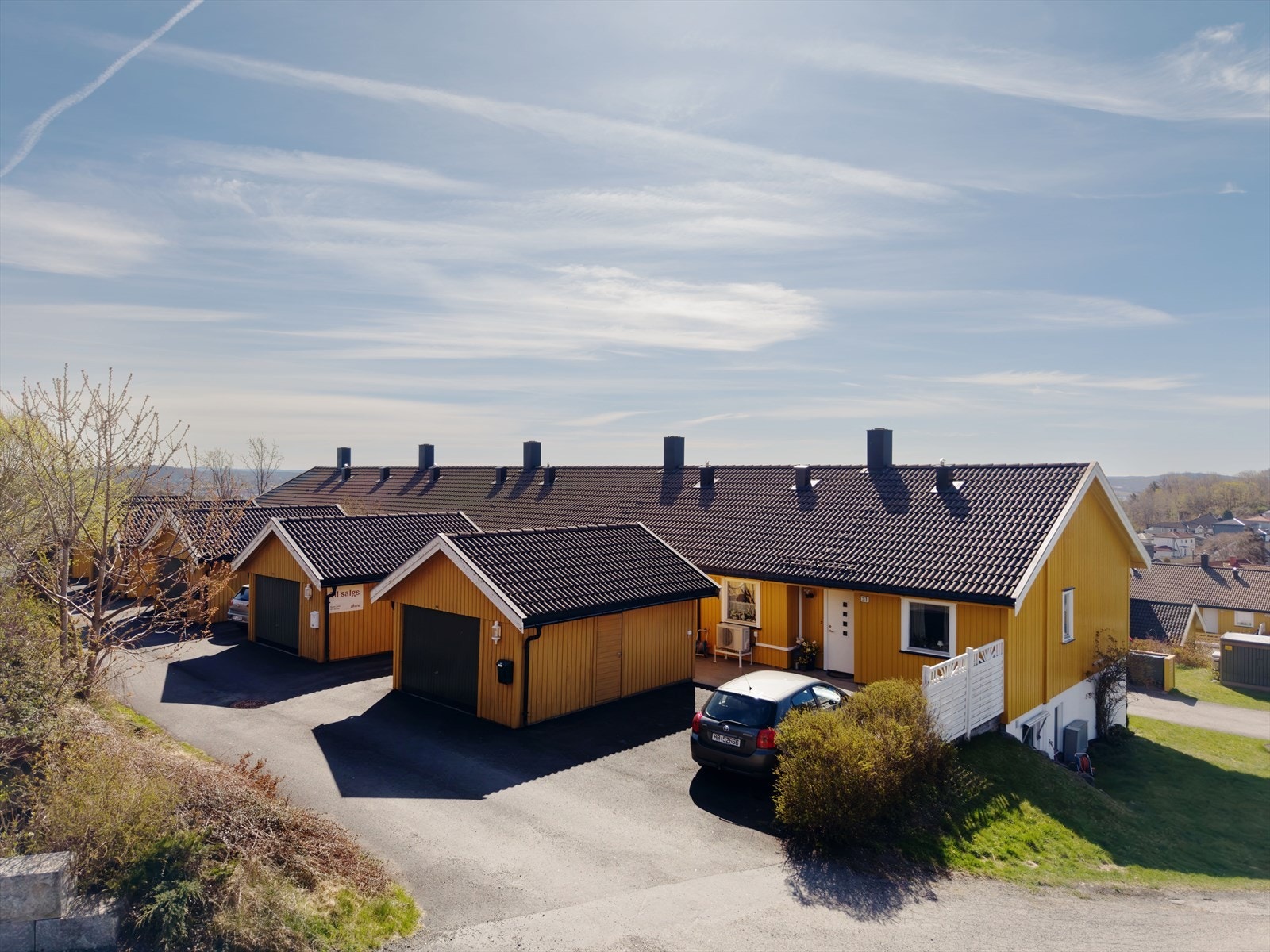 Innkjørsel og adkomst til boligen, med oversiktlig og lett tilgjengelig inngang. Garasjen er rett utenfor. Galleribilde