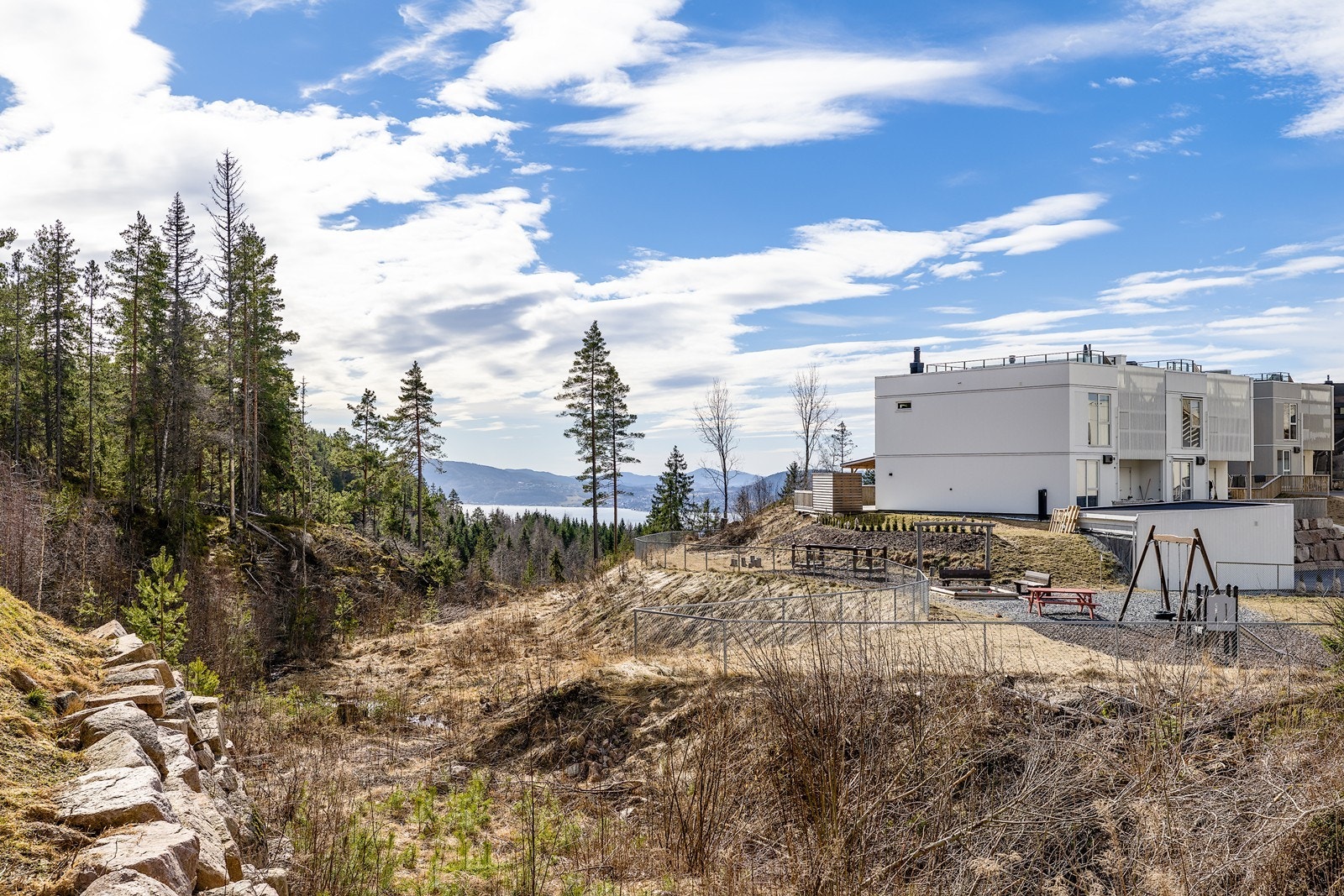 Utsikten fra tomten strekker seg over det omkringliggende landskapet, med en fin kombinasjon av natur og bebyggelse. Galleribilde
