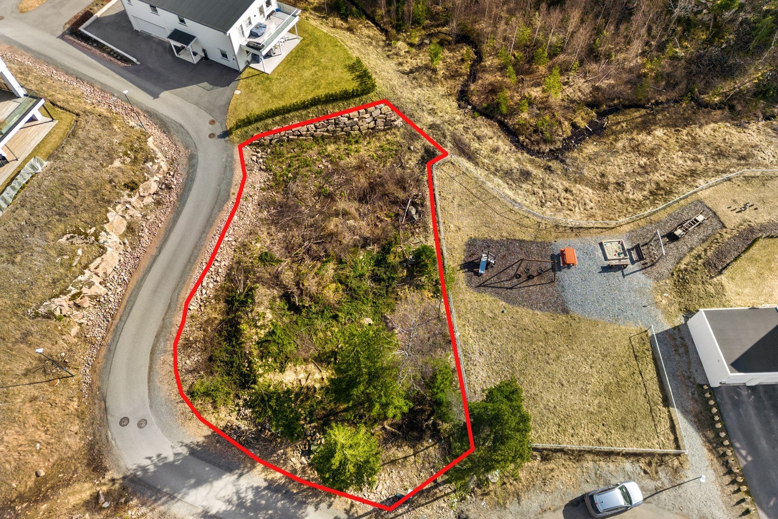 Den skrånende topografien er ideell for en bolig med underetasje og utgang til hage på et lavere nivå. Galleribilde
