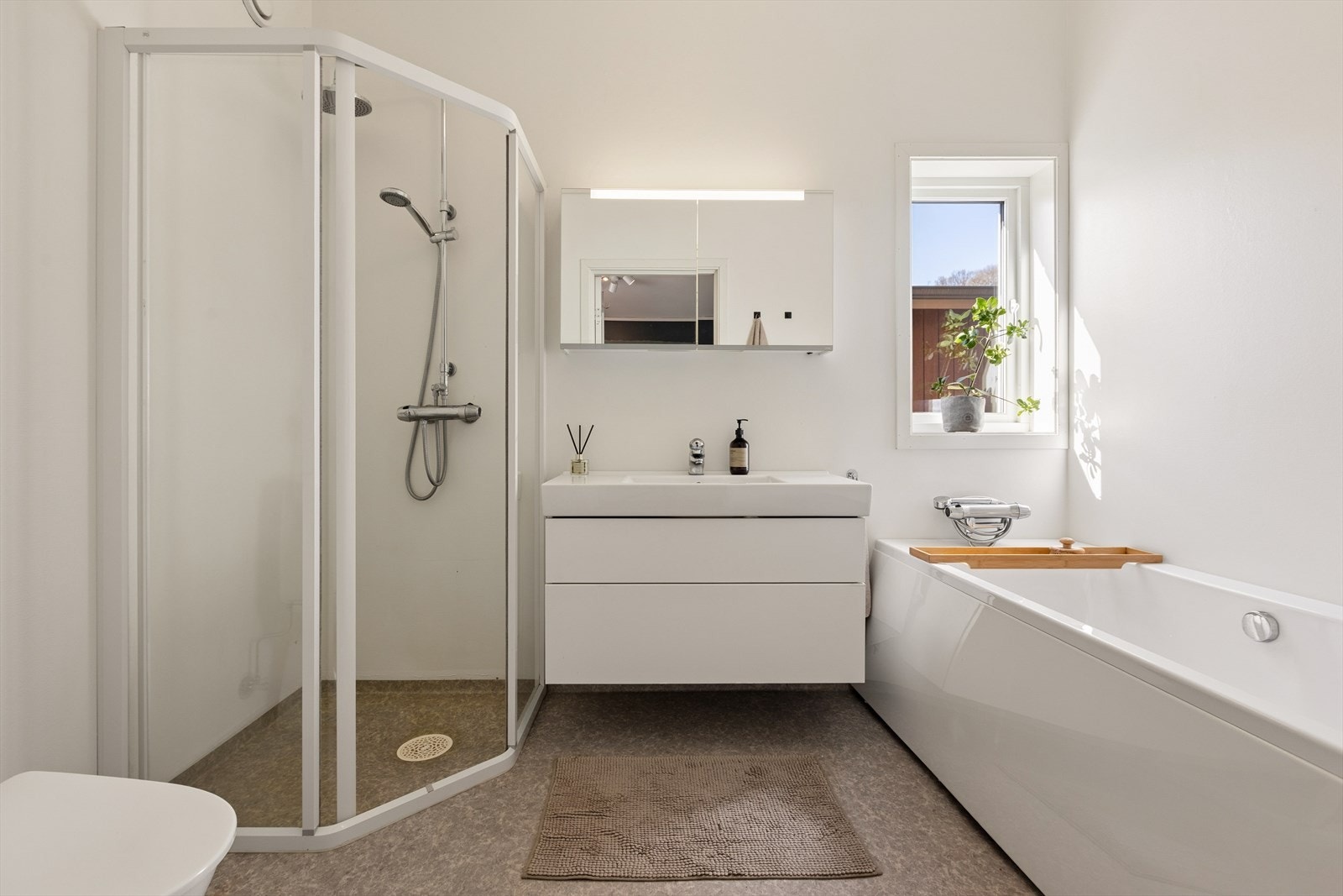 Badet i 2.etasje er utstyrt med badekar, hjørnedusj, baderomsinnredning med underskap, og overskap med integrert speil og belysning. Galleribilde