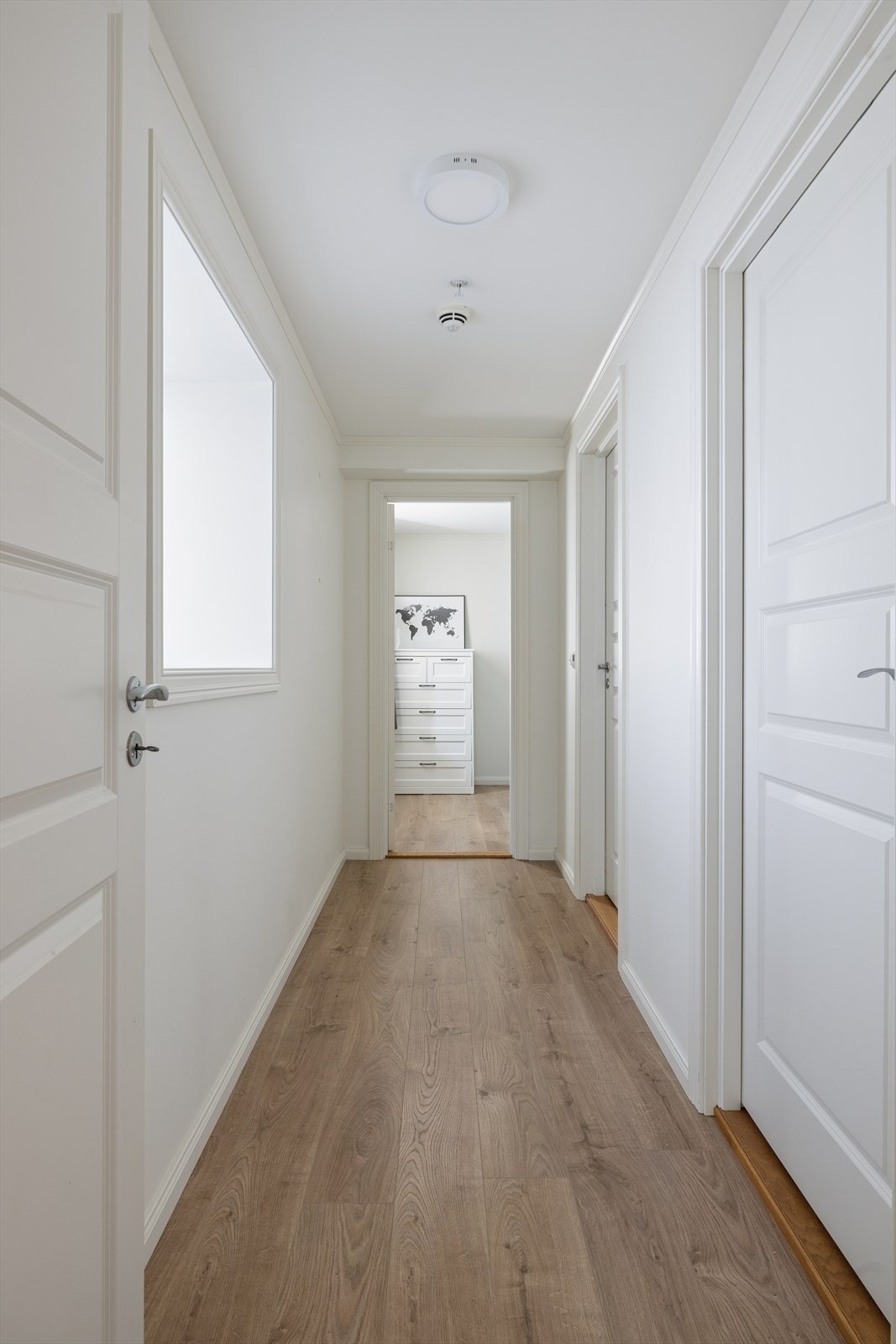 En lys gang forbinder stue/kjøkken med bad, bod/vaskerom og et av soverommene. Galleribilde