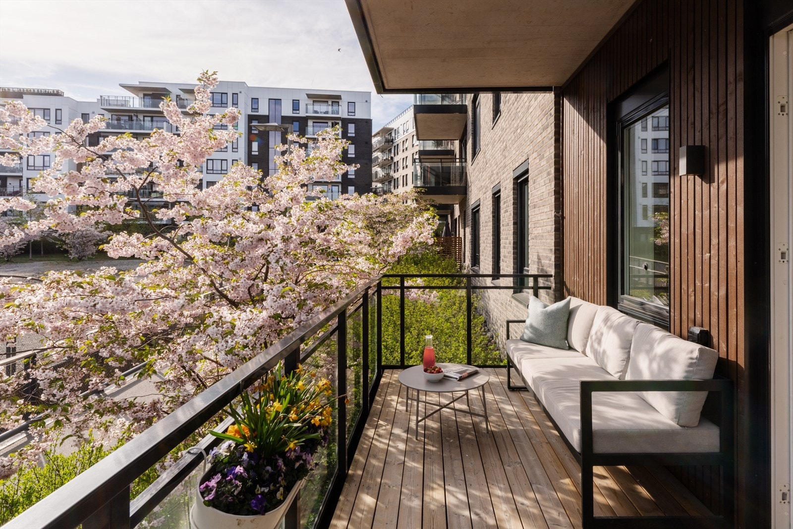 Utgang til en stor, sydvestvendt balkong på 12 m². Om våren skaper blomstrende kirsebærtrær en ekstra hyggelig atmosfære. Galleribilde