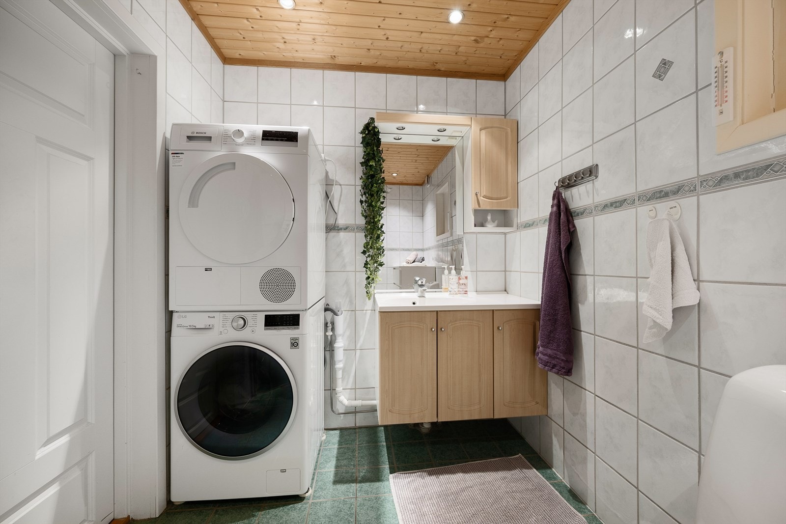 Badet i første etasje har flislagte overflater, gulvvarme og opplegg for vaskemaskin. Galleribilde