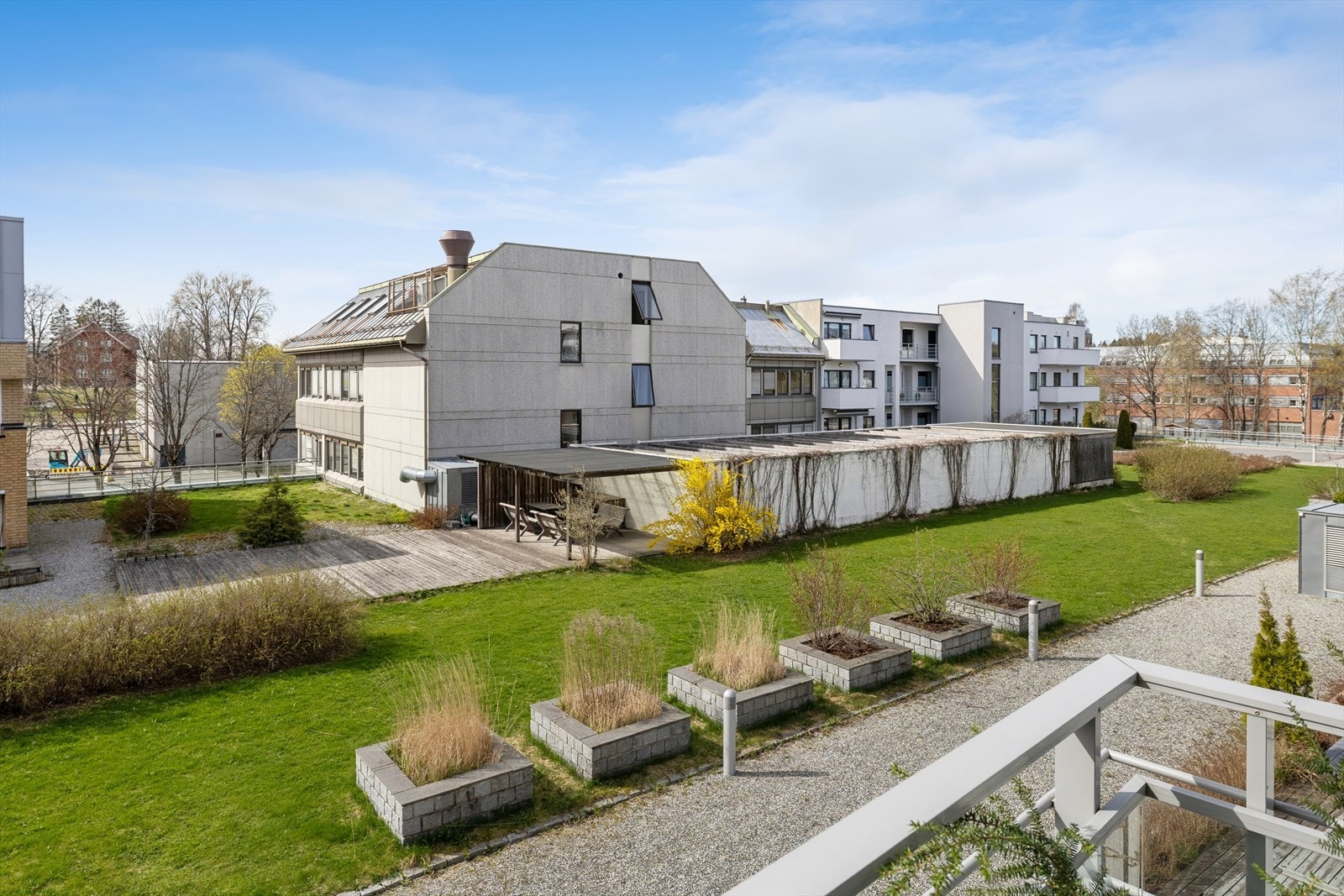Utsikt fra balkongen mot det grønne atriet mellom bygningene. Galleribilde