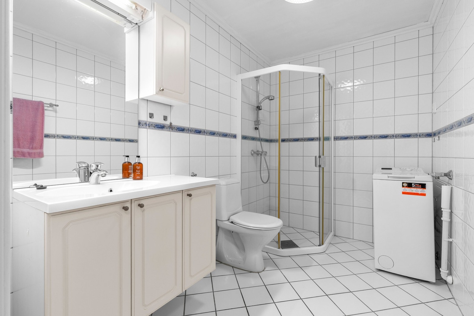 Bad med innredning, wc, dusjhjørne og opplegg til vaskemaskin Galleribilde