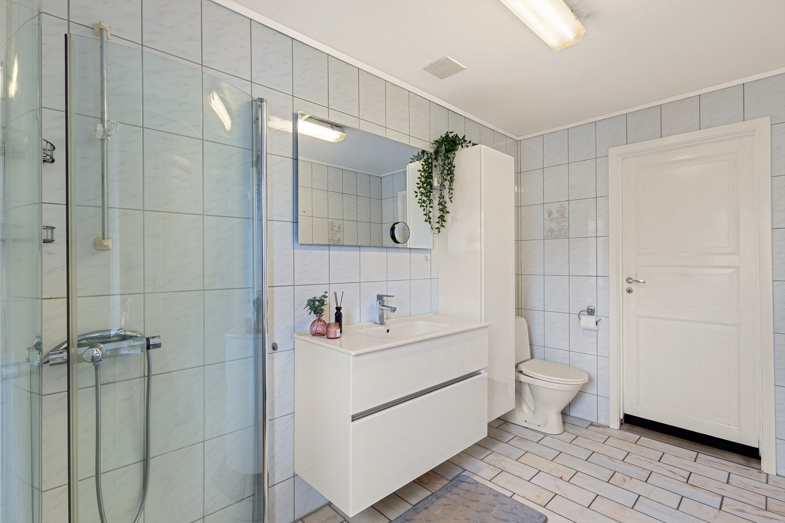 Badet er utstyrt med wc, dusjvegger og baderomsinnredning. Galleribilde