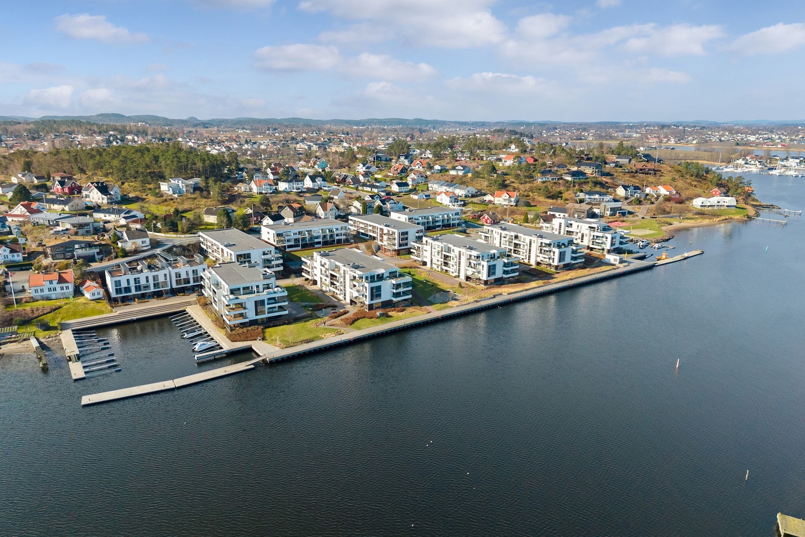 Rundt 200 meter fra leiligheten er det en stor gresslette med volleyballbane og lekeplass, samt strandlinje. Galleribilde