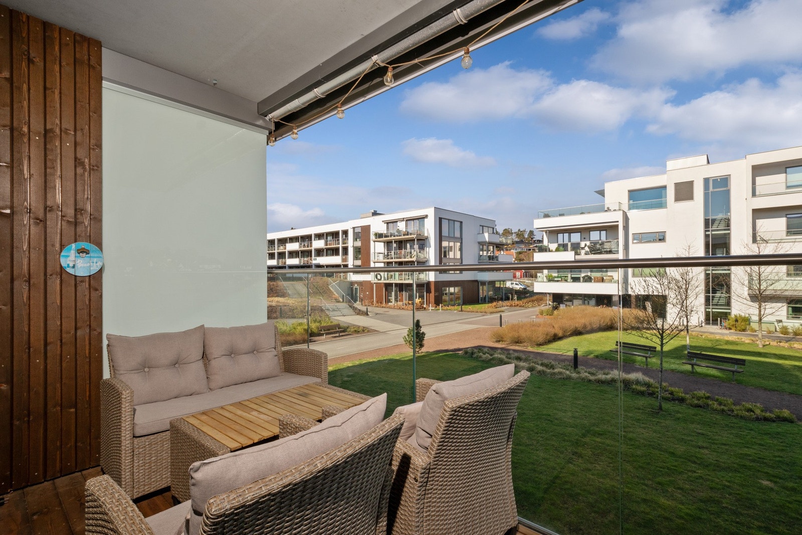 Balkongen har terrassebord på støpt dekke og rekkverk i stål med store glassflater. Galleribilde