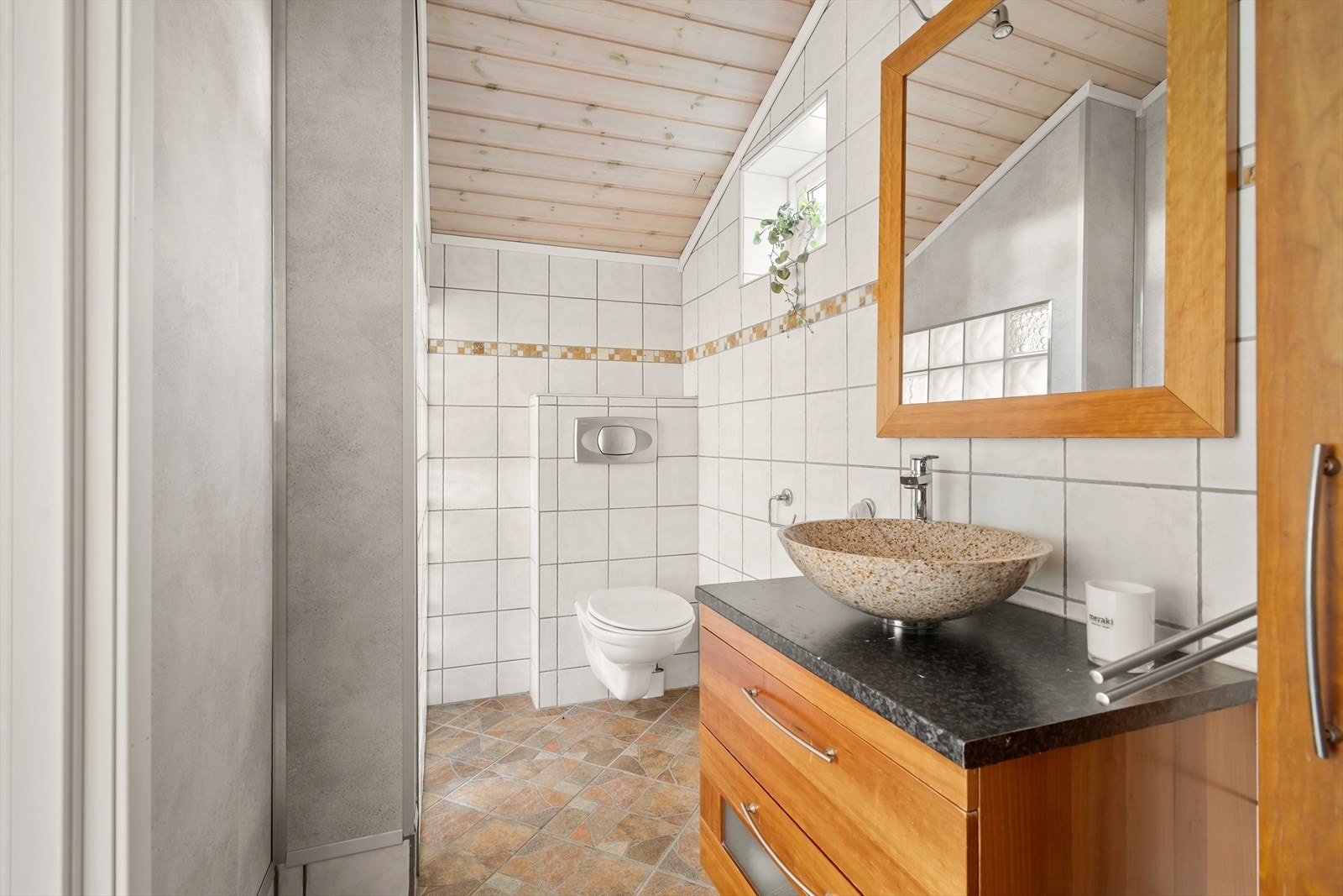 Det ene badet i første etasje har flislagte overflater, vegghengt toalett og dusjhjørne. Galleribilde