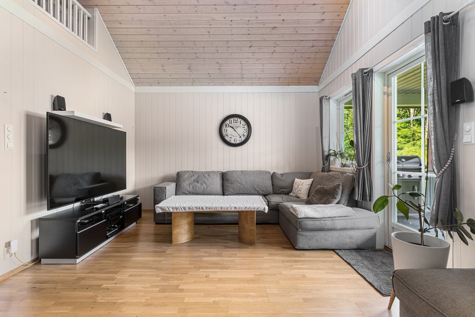Lys og luftig tv-stue med plass til en større sofagruppe , bord og tv-benk. Galleribilde