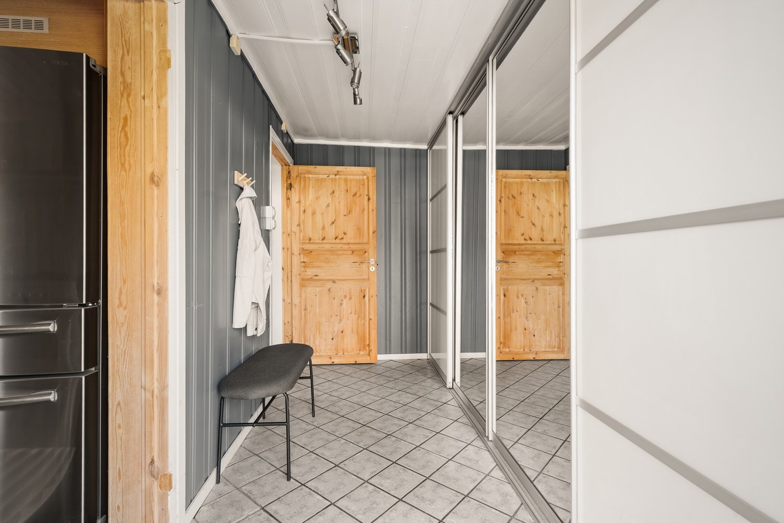 Entréen har flislagt gulv og god plass til oppbevaring i skyvedørsgarderobe. Galleribilde