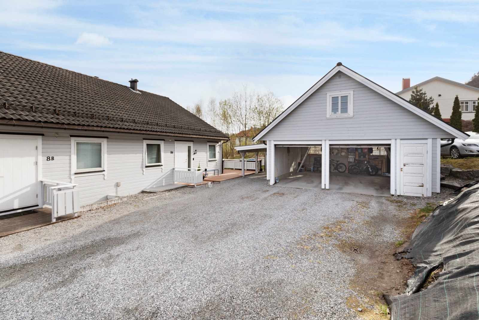 Gruset innkjørsel og biloppstillingsplass. Boligen disponerer halvpart av dobbelgarasje. Galleribilde