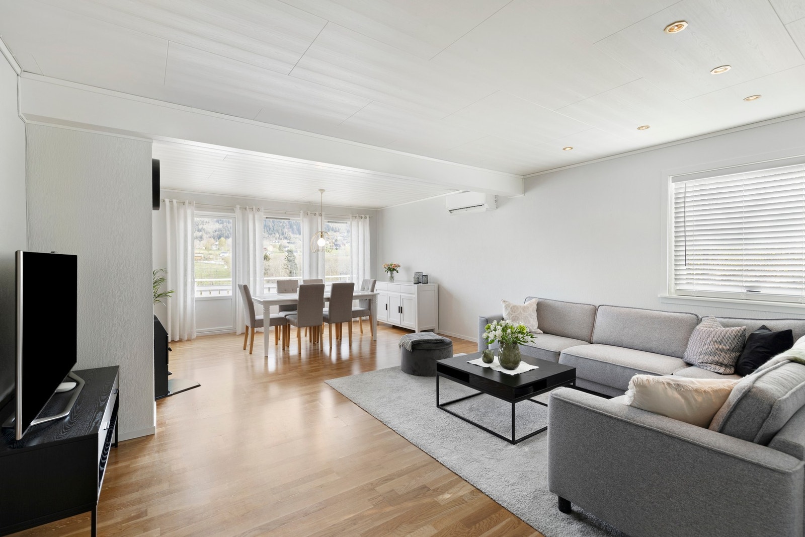 Lys og romslig stue med parkett på gulv og tapet på vegger. Galleribilde