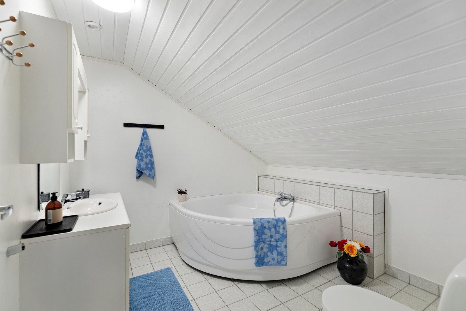 Badet i loftsetasjen har flislagt gulv med varmekabler og våtromstapet på vegger. Galleribilde