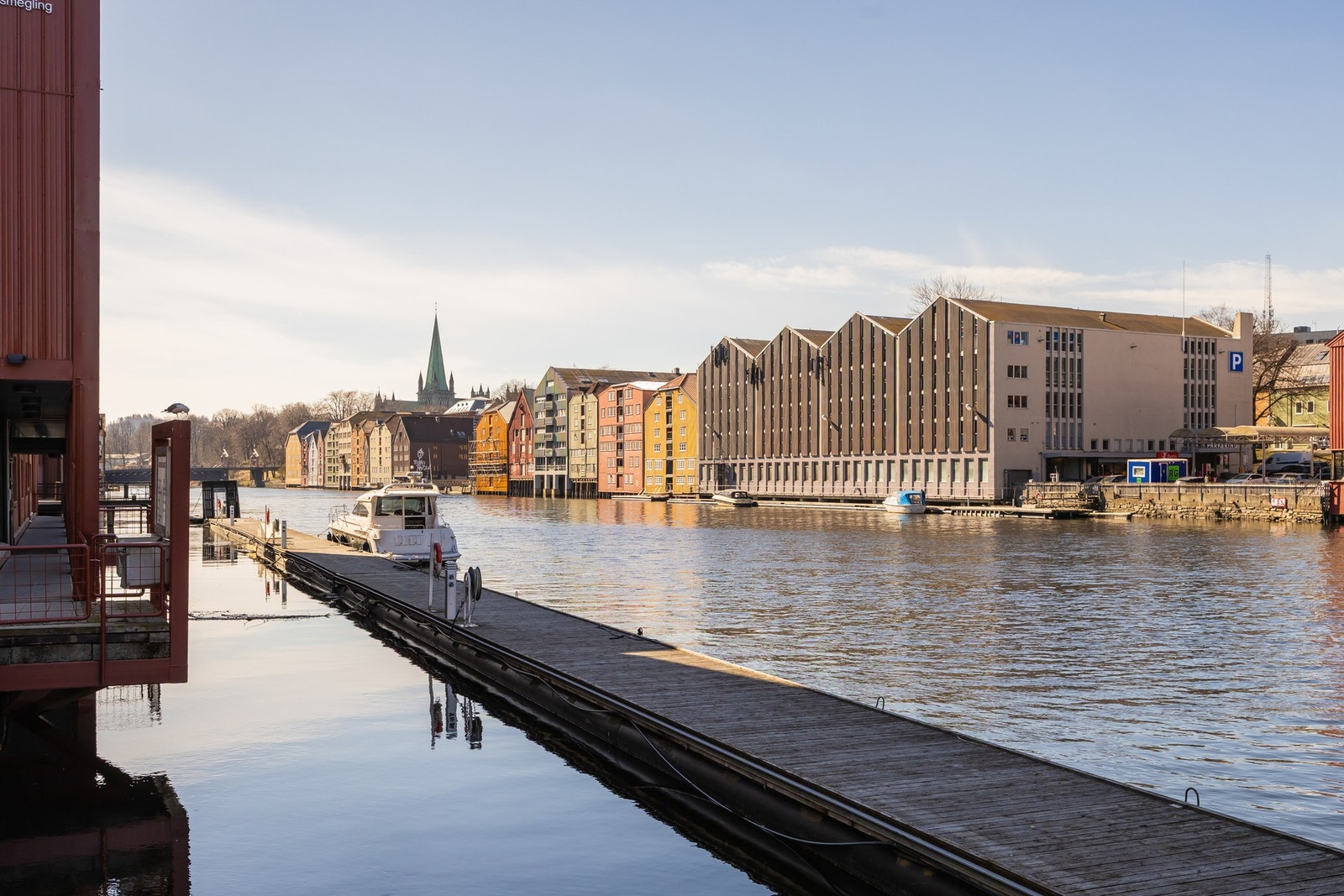 Man kan vandre via bryggehus og elvepromenaden langs Nidelva. Galleribilde