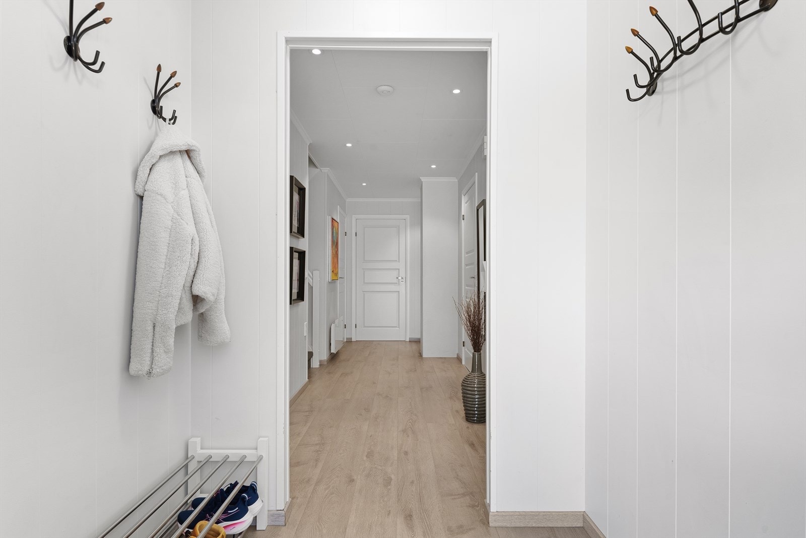 Gangen binder sammen rommene i første etasje. Overflatene består av laminat på gulv og malte panelplater på veggene. Galleribilde