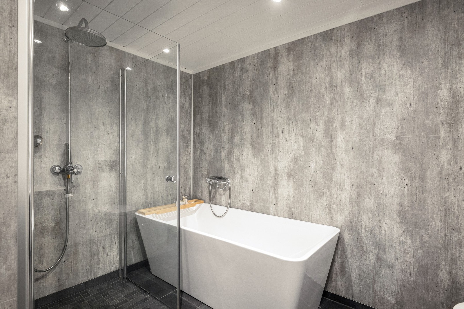 Badet er innredet med badekar med badekararmatur
tilkoblet hånddusj samt dusjhjørne. Galleribilde