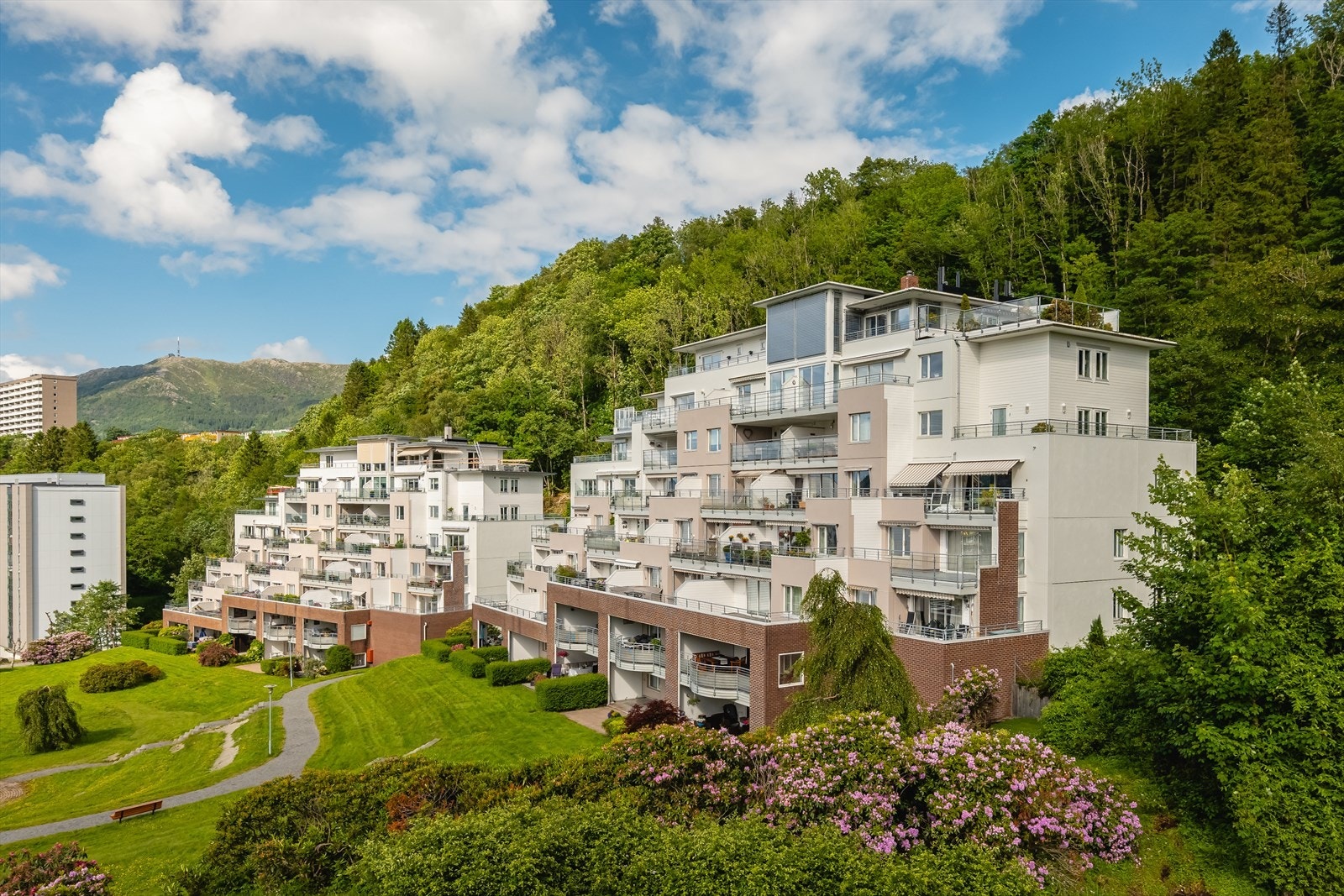 Boligblokken ligger fint til i terrenget med grønne omgivelser. Galleribilde