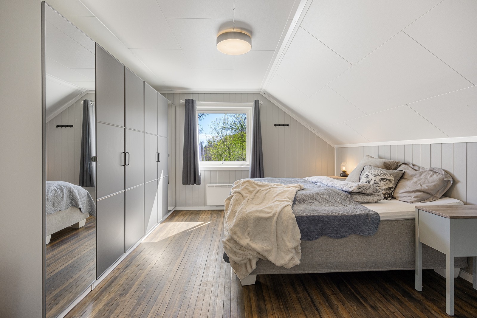 Store vinduer sørger for rikt, naturlig lysinnslipp til rommene. Dette rommet har en stor skyvedørsgarderobe. Galleribilde