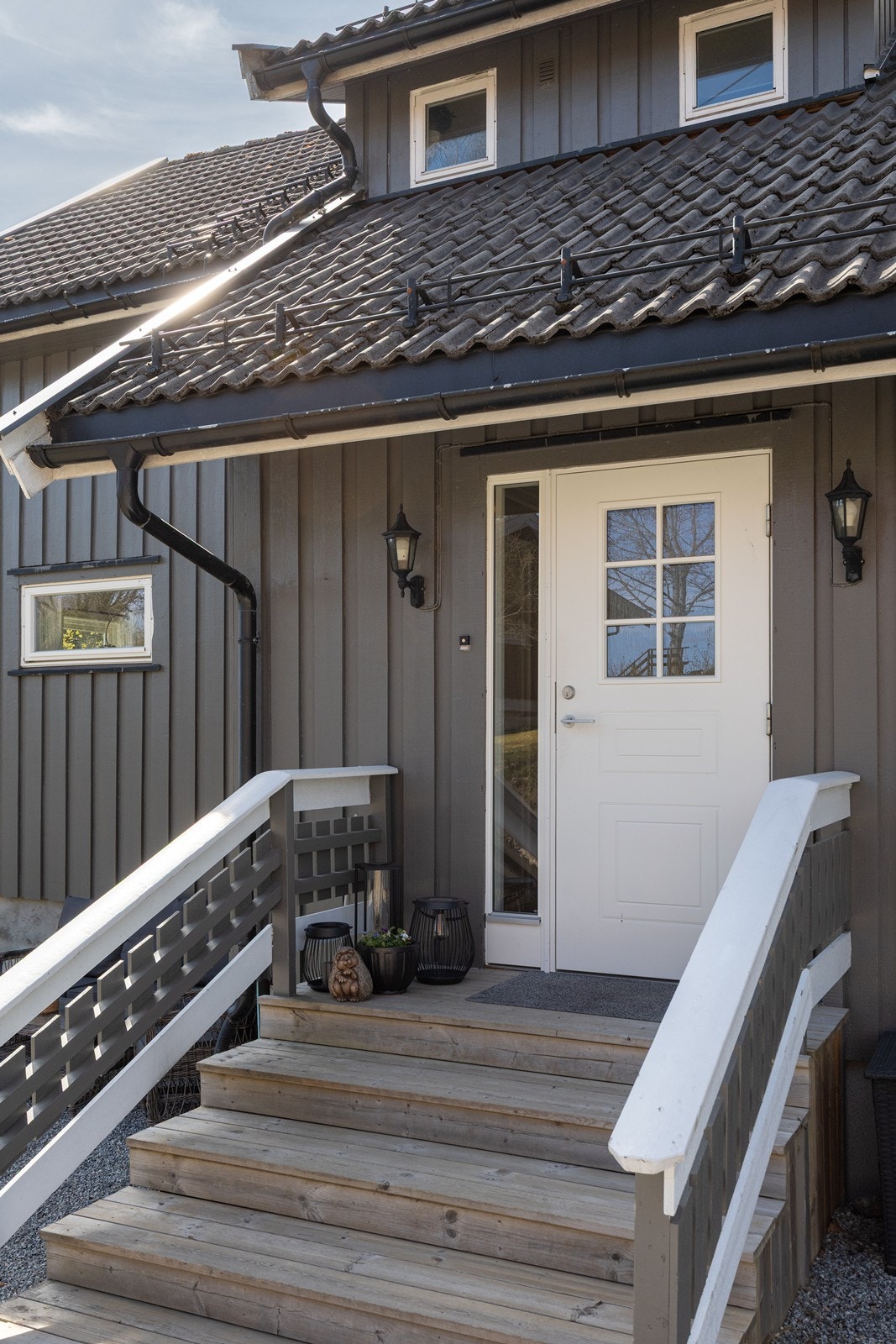 Eneboligen har et pent, overbygd inngangsparti med gruslagt adkomst, bred tretrapp og veggmontert utebelysning. Galleribilde