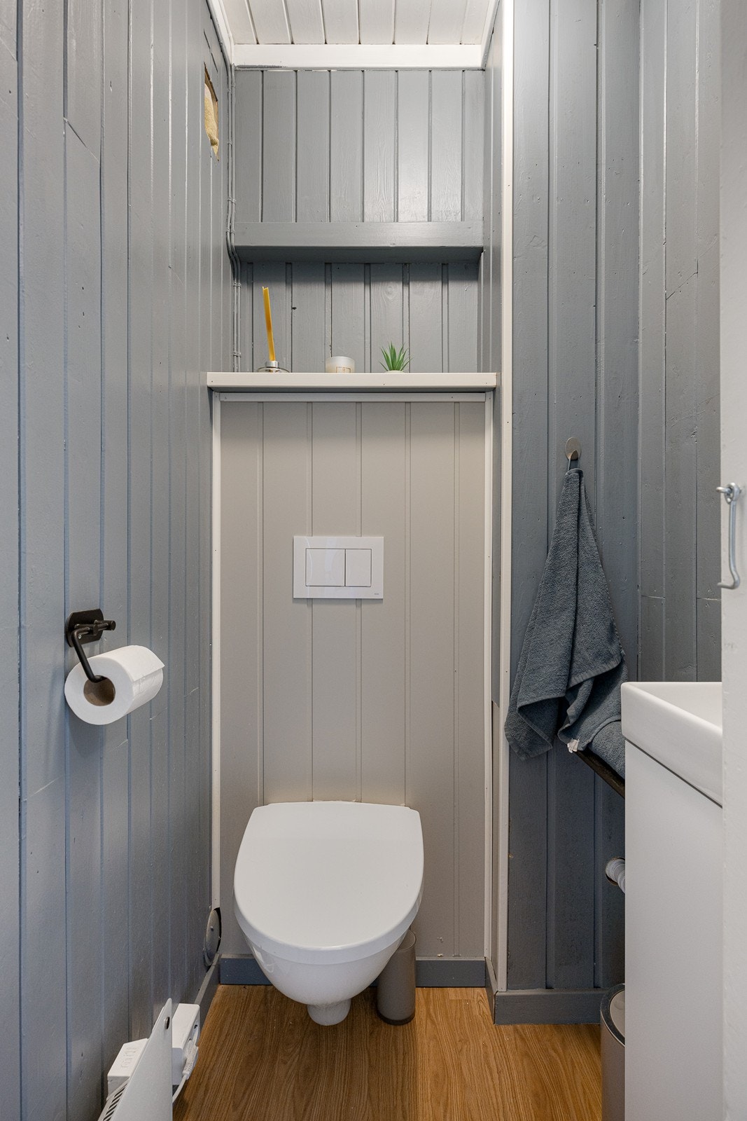 I hendig tilknytning til entreen i første etasje er det et pent, nyere wc-rom med malt panel på veggene og gyllent belegg på gulvet. Galleribilde