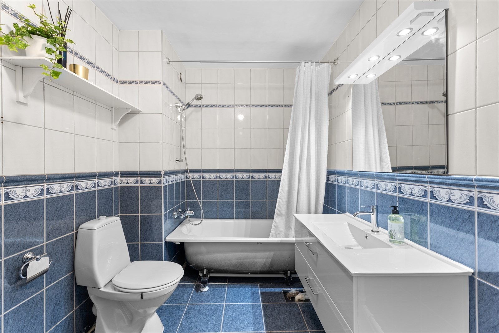 adet er innredet med badekar, servant med baderomsmøbel og speil som følger med ved salg. Det er opplegg for både vaskemaskin og tørketrommel. Galleribilde