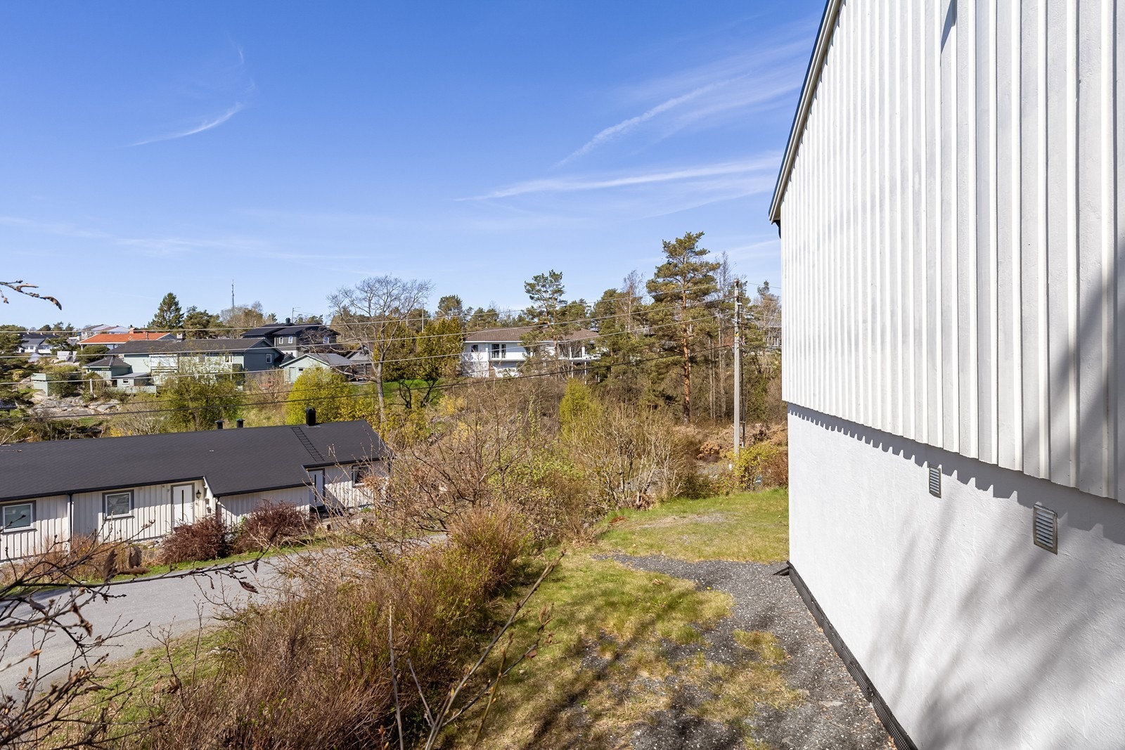 Tomten går rundt huset, og er opparbeidet med hekk og plen. Galleribilde