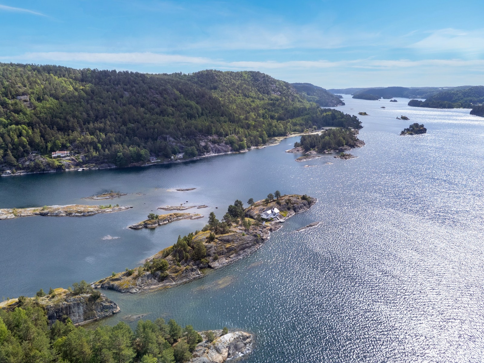 Eiendommen ligger vakkert til i Sørfjorden, omgitt av svaberg, glitrende sjø og frodig kystlandskap Galleribilde