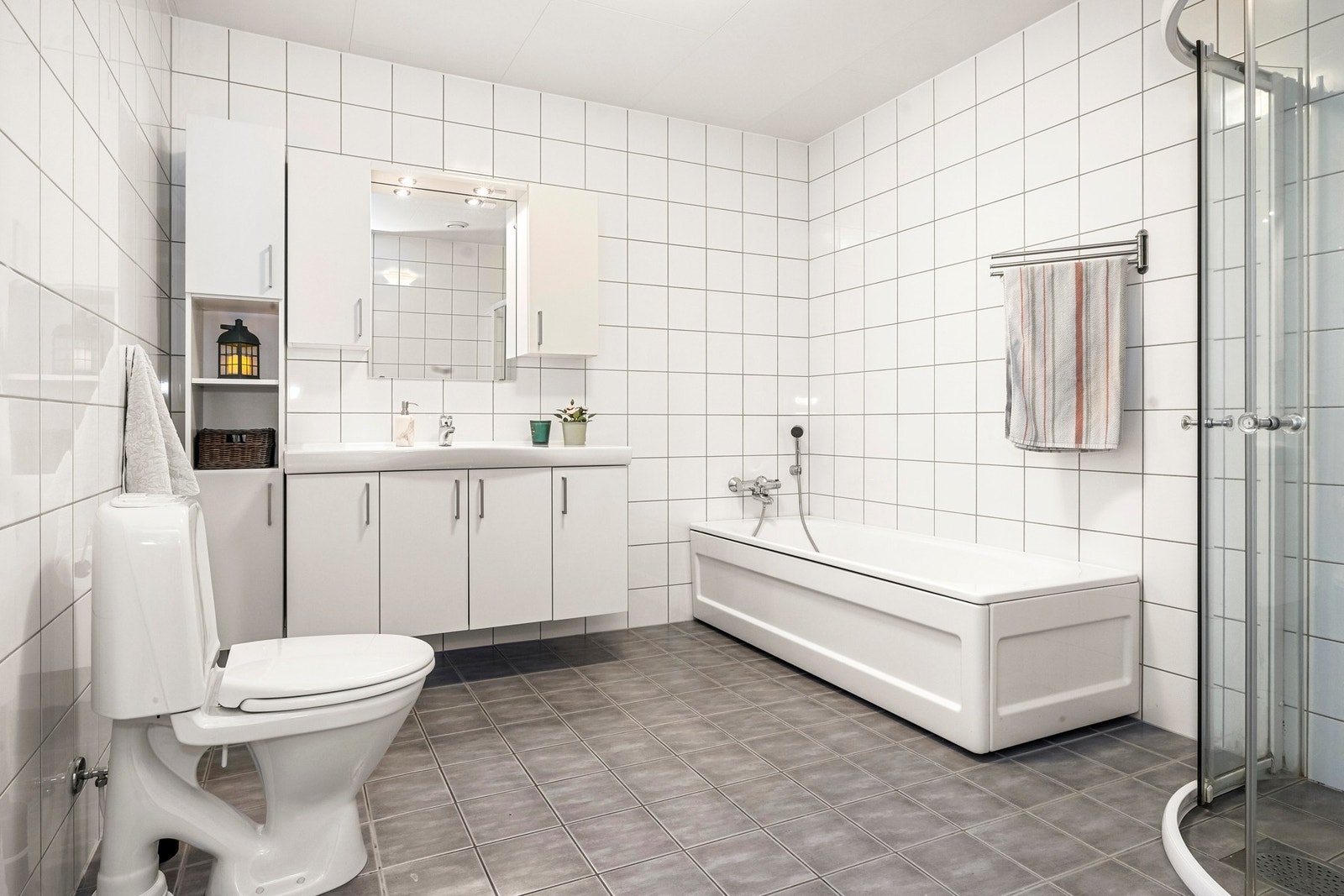 Badet har innredning med nedfelt servant, gulvfestet toalett, badekar og dusjhjørne - og selvsagt barfotvennlige varmekabler. Galleribilde