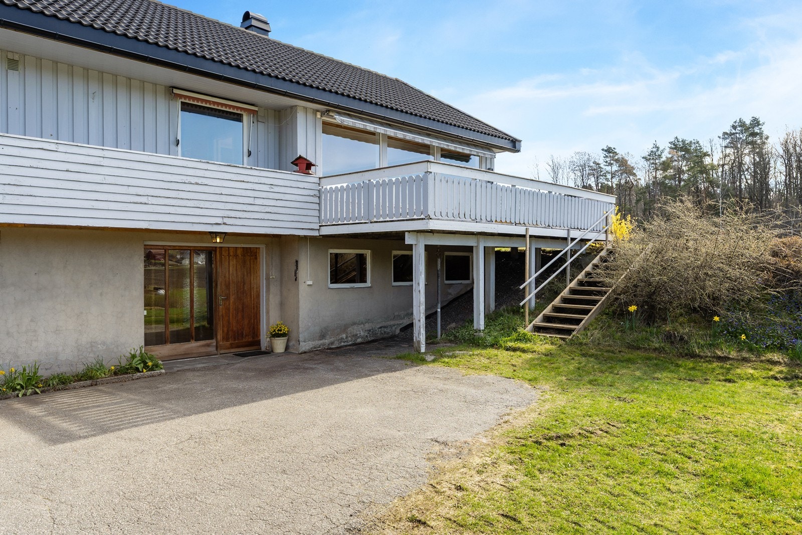 Fra gårdsplassen er det trapp som gir adkomst til den store terrassen og hagen. Galleribilde