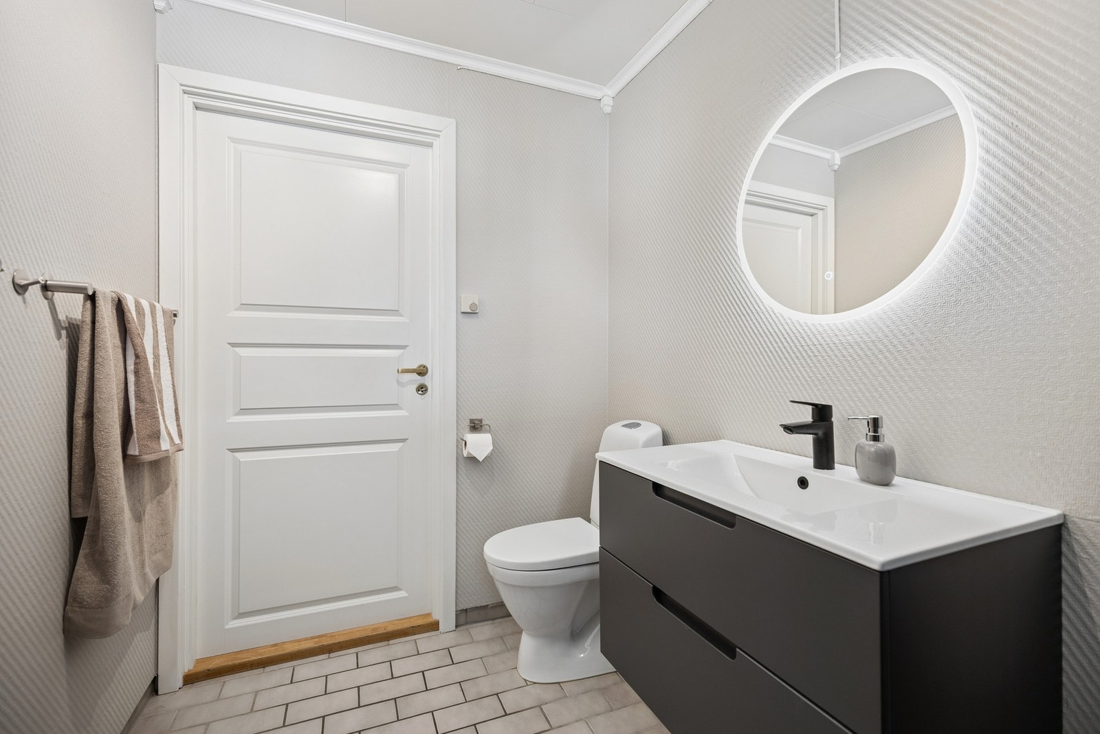 Stilrent toalettrom med moderne servant, speil med belysning. Galleribilde