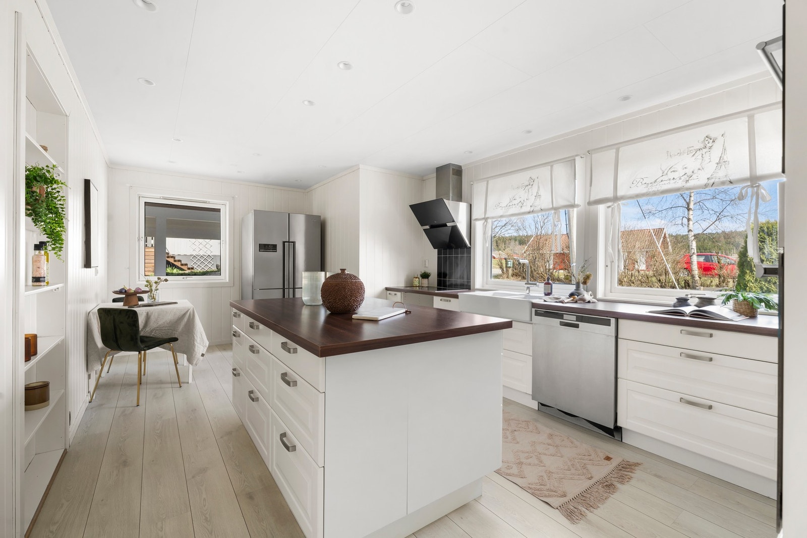 Delikat kjøkken med åpen løsning og elegant kjøkkenøy som naturlig midtpunkt. Galleribilde