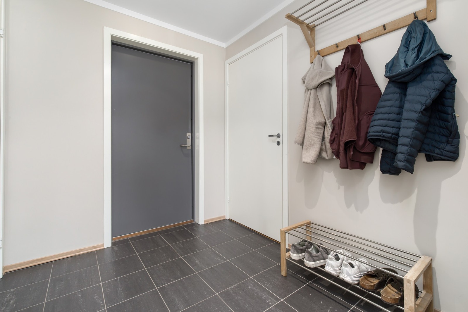 Leilighetens entré der man har plass til å henge fra seg yttertøy. Her har de slått sammen bodene for å få fjerne den ene døren å få bedre plass. Galleribilde