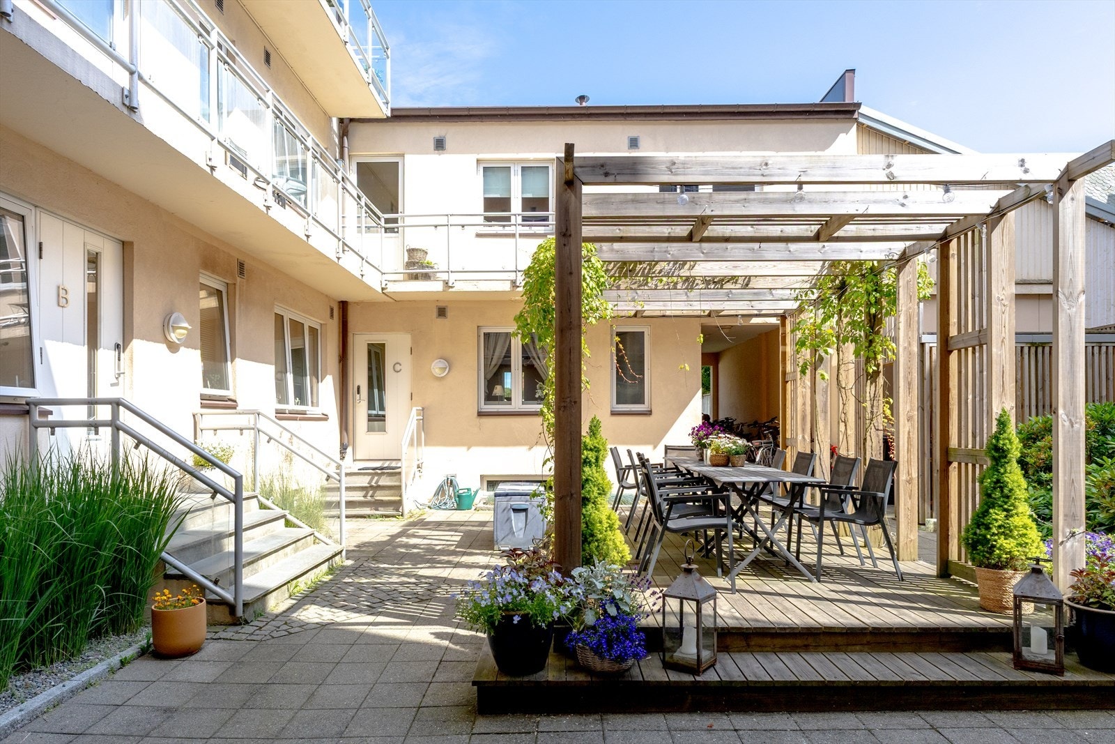 Skjermet og hyggelig bakgård med sitteplasser og steinlagte arealer. Galleribilde