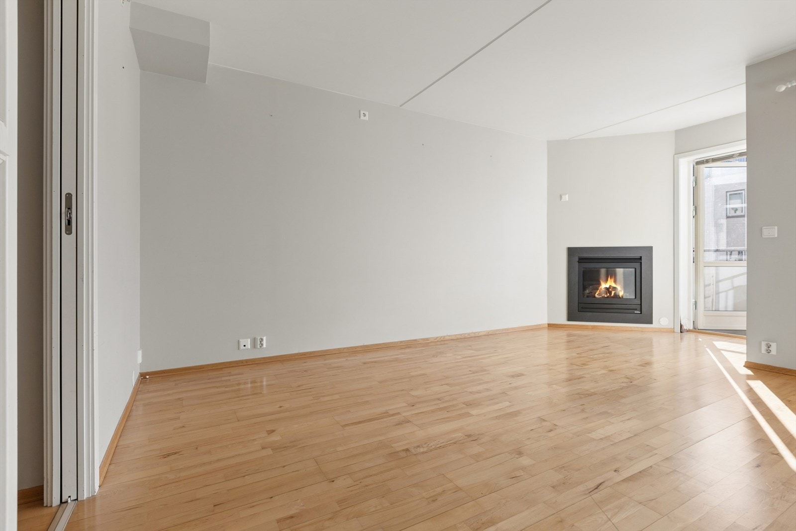 Rommet har parkett på gulv, og hvitmalte vegger. Hit strømmer dagslyset inn fra sjenerøse vindusflater og glassdør mot balkong. Galleribilde
