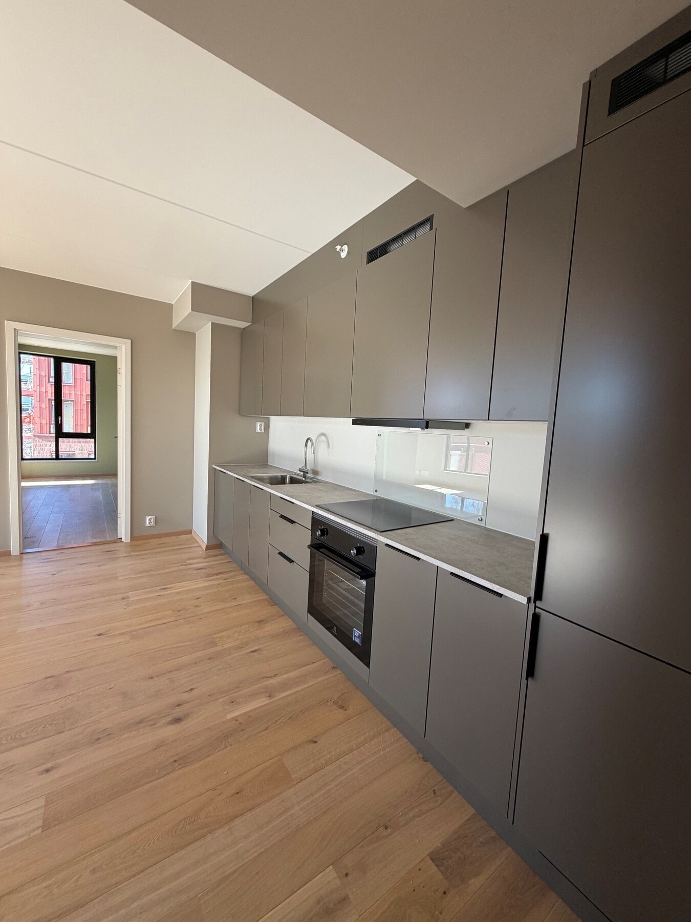 Innredningen er i en mørk beige farge som heter S7005-Y20R Høst (STD) kombinert med en lys benkeplate. Galleribilde