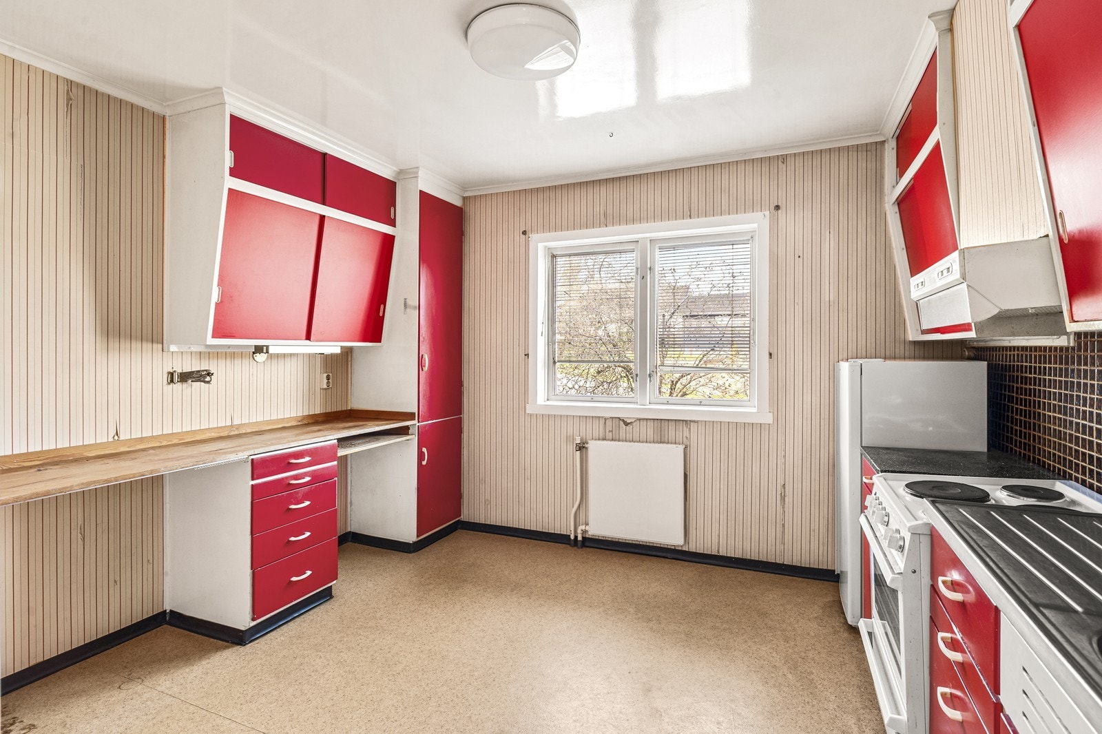 Kjøkkenet har innredning fra byggeåret og god plass til spisebord. Et rom klart for modernisering etter egne ønsker. Galleribilde