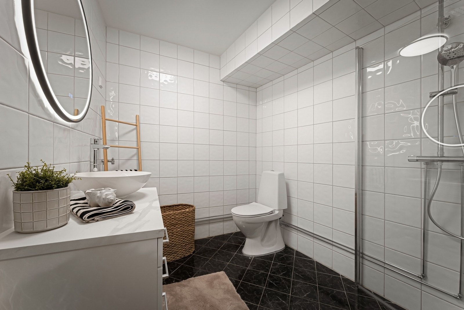 Moderne, flislagt baderom med varmekabler og opplegg for vaskemaskin. Galleribilde