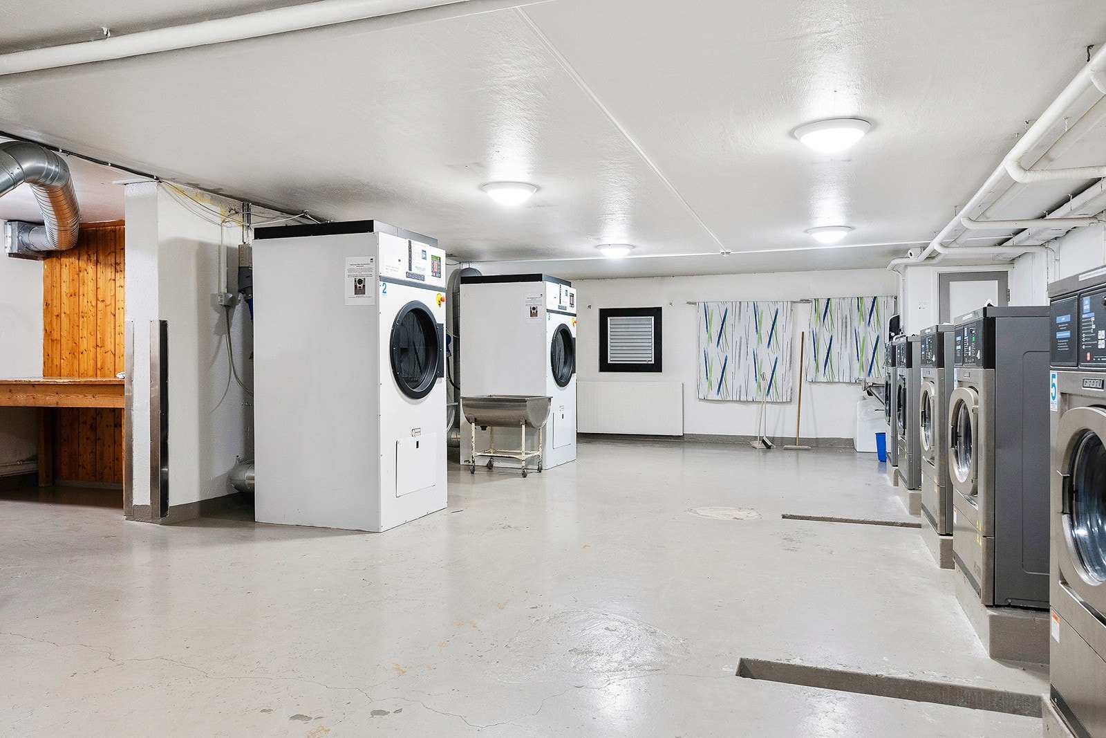 Praktisk fellesvaskeri med store industrimaskiner. Galleribilde