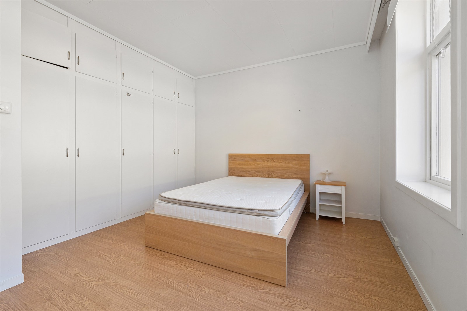 En hel vegg med plassbygde garderobeskap gir rikelig med oppbevaringsplass på soverommet. Galleribilde